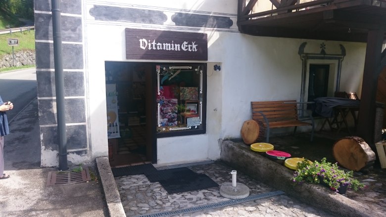 Vitamin-Eck, © Tourismusverein Göstlinger Alpen Eingang eines kleinen Ladens namens Vitamin-Eck mit Sitzbank und Dekorationen aus Holz und Blumen.