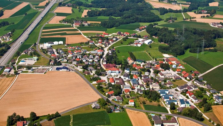 Viehdorf, © Gemeinde Viehdorf Luftaufnahme eines Dorfes mit Feldern und einer Autobahn.