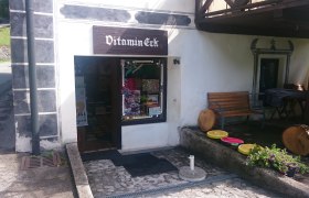 Vitamin-Eck, © Tourismusverein Göstlinger Alpen Eingang eines kleinen Ladens namens Vitamin-Eck mit Sitzbank und Dekorationen aus Holz und Blumen.