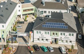 Gasthof zum Alten Brauhaus, © Markus Haslinger Luftaufnahme eines Gebäudekomplexes mit dem Gasthof zum Alten Brauhaus, Solarpanels auf dem Dach und mehreren geparkten Autos.