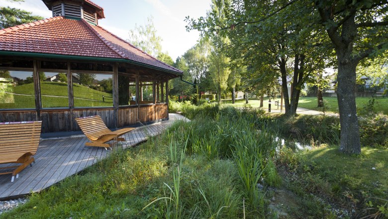 SoleAerium, © Stadtgemeinde Mank Holzpavillon mit Liegestühlen in einem grünen Park.