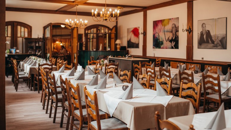 Cozy: Colorful Tiffany windows and wooden lamperie, © Niederösterreich Werbung/Daniela Führer A cozy dining room with wooden furniture, laid tables and chandeliers.