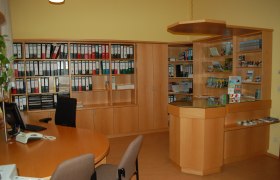 Tourismusbüro Gaming, © Tourismusbüro Gaming Innenansicht eines Büros mit Holzregalen, Aktenordnern und einem Empfangstresen.