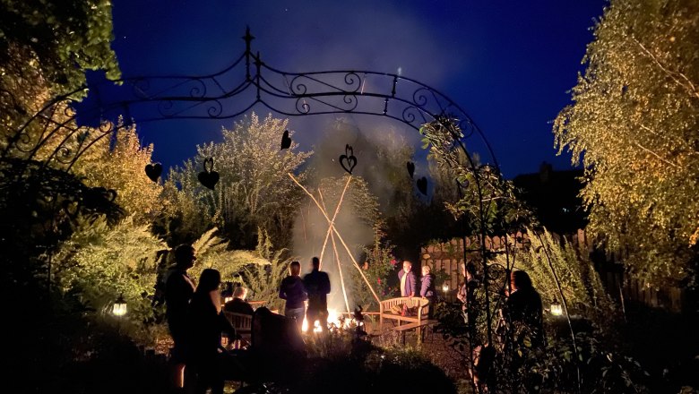 Smoking in the garden, © Monika Vesely People gather around a campfire in the garden at night.
