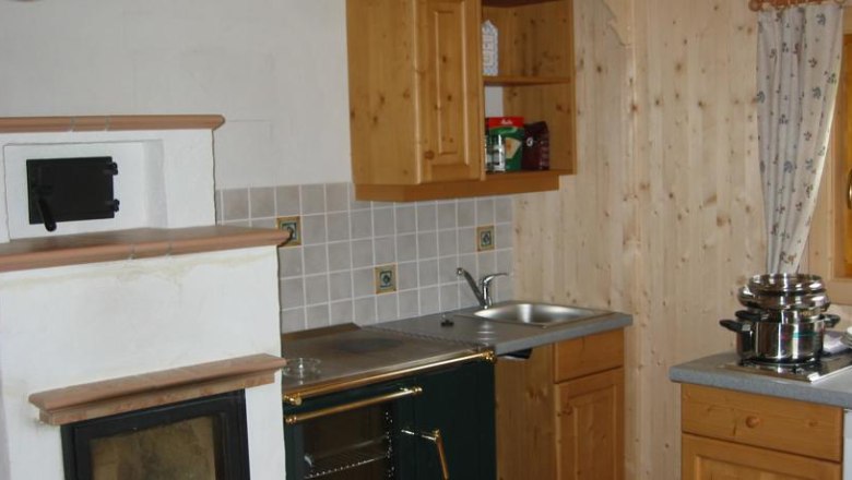 Lassing-Hochkar vacation village, © Feriendorf Lassing Kitchen in a rustic style with wooden cupboards, an oven and a stove.