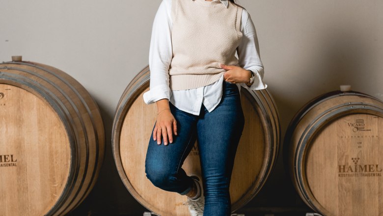 TDR-Winery Haimel, © David Schreiber A woman leans smiling against a wine barrel at the Haimel winery.
