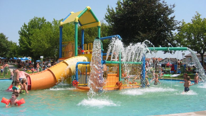 Wasserspielgarten Neumarkt, © Gemeinde Neumarkt an der Ybbs Kinder spielen in einem Wasserspielgarten mit Rutschen und Wasserfontänen.