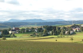Gemeinde St. Margarethen an der Sierning, © Gemeinde St. Margarethen Landschaft mit Dorf und Kirche in St. Margarethen an der Sierning, umgeben von Feldern und Hügeln.
