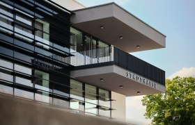 Aussenansicht Stadthalle Ybbs, © Johann Perger Moderne Außenansicht der Stadthalle Ybbs mit Glasfassade und Balkon.