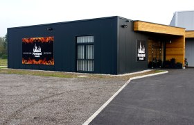 Aussenansicht Fireland Foods, © zVg Außenansicht eines modernen Gebäudes mit Fireland Foods Logo und Slogan.