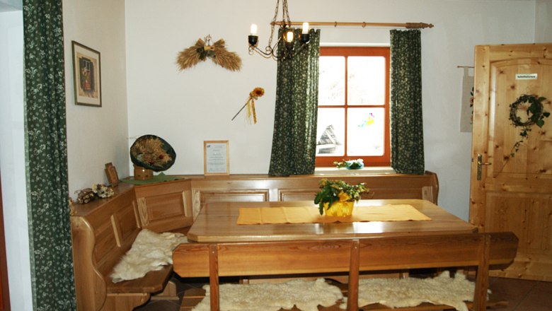 Aufenthaltsraum, © zVg Gemütlicher Aufenthaltsraum mit Holzmöbeln, Tisch, Eckbank und Dekorationen an der Wand.