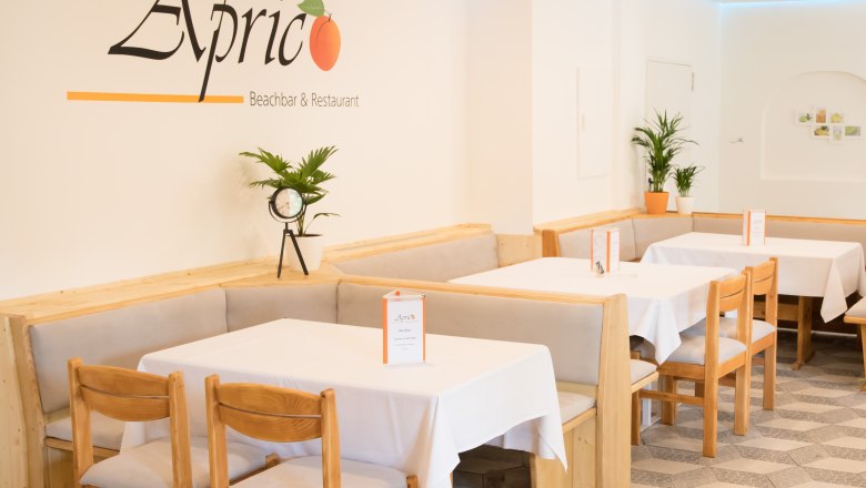 Beachbar & Restaurant Aprico, © Aprico Gastraum mit Tischen und Stühlen sowie weißer Tischwäsche