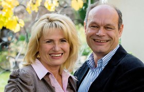 Gasthof Pitterle, © Helmut Lackinger Ein lächelndes Paar steht draußen vor einem Hintergrund mit gelben Blättern.