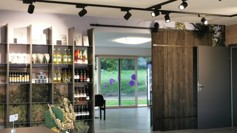 Hofladen Familie Öllerer in Sitzenberg-Reidling, © Elfriede Öllerer Ansicht des Hofladens mit Blick auf ein Regal mit Wein und anderen Produkte.