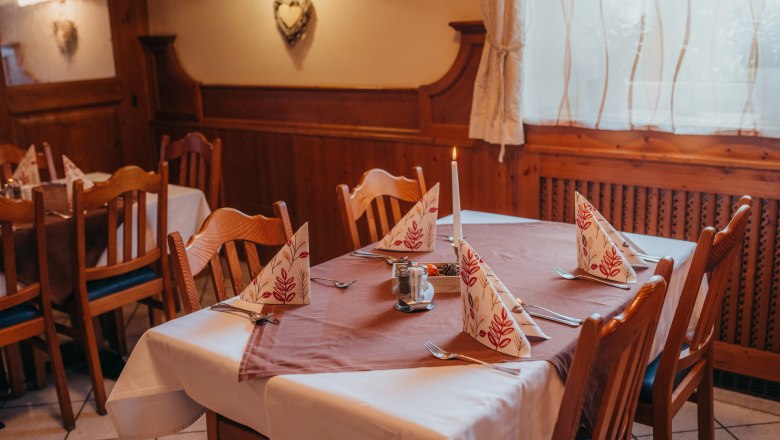 Cozy with space for parties, © Niederösterreich Werbung/Daniela Führer Comfortably laid table in a rustic restaurant with wooden paneling.
