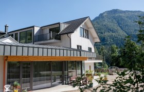 Haus am See, © schwarz-koenig.at Modernes Haus mit Berg im Hintergrund an einem sonnigen Tag.