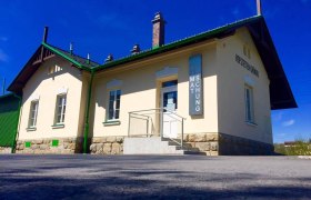 Station museum from the outside, © Heimatmuseum Hofstetten-Grünau Exterior view of a small museum building with a yellow façade and green accents.