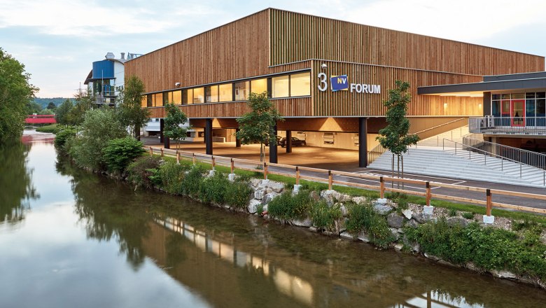 Wieselburg Trade Fair, © Andreas Buchberger Modern Messe Wieselburg building with wooden façade and river in the foreground.