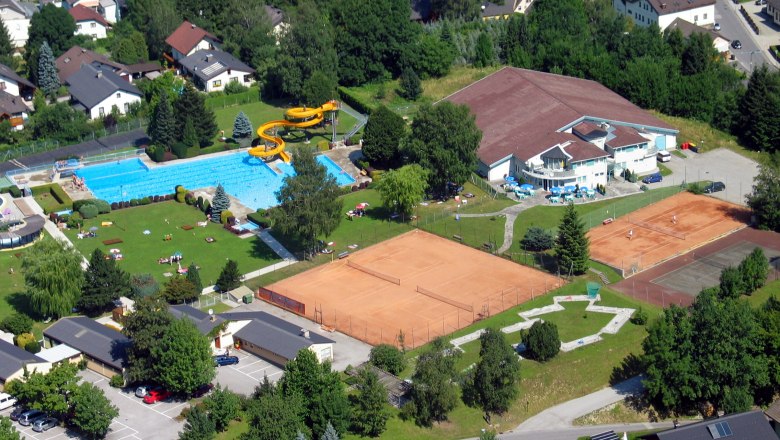 Aerial view of Gaming outdoor pool, © Hans-Peter Schager Aerial view of an outdoor pool with swimming pool, slide and tennis courts in a residential area.