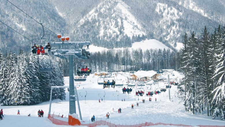 Forsteralm, © zVg Forsteralm Skigebiet Forsteralm mit Sessellift und schneebedeckten Bäumen.