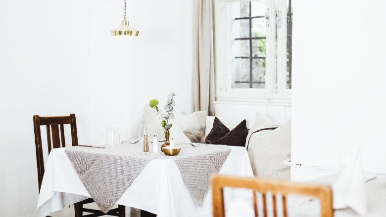 Combining culture and enjoyment, © Niederösterreich Werbung/David Schreiber Comfortably furnished restaurant with wooden furniture and table decorations.