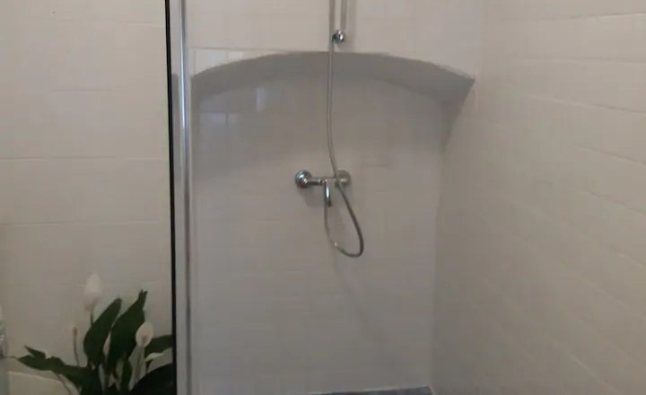 Badezimmer Ansicht, © Fam. Obernberger Moderne Dusche mit blauen Fliesen und weißen Wänden.