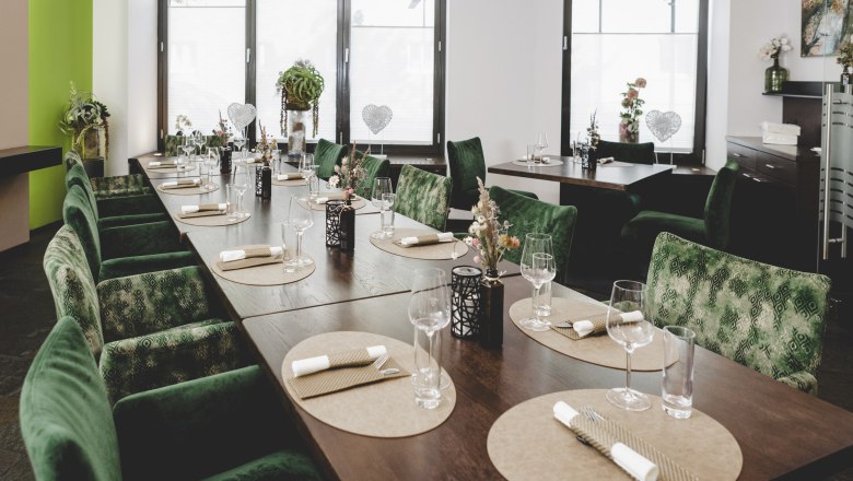 Hospitable family business in the heart of Lower Austria, © Niederösterreich-Werbung/David Schreiber Elegant restaurant with green chairs and table setting.