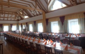 Gasthaus Griessler, © zur Verfügung gestellt: Gasthaus Griessler Innenansicht eines Gasthauses mit gedeckten Tischen und Holzbalkendecke.