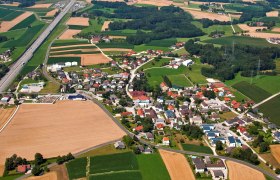 Viehdorf, © Gemeinde Viehdorf Luftaufnahme eines Dorfes mit Feldern und einer Autobahn.
