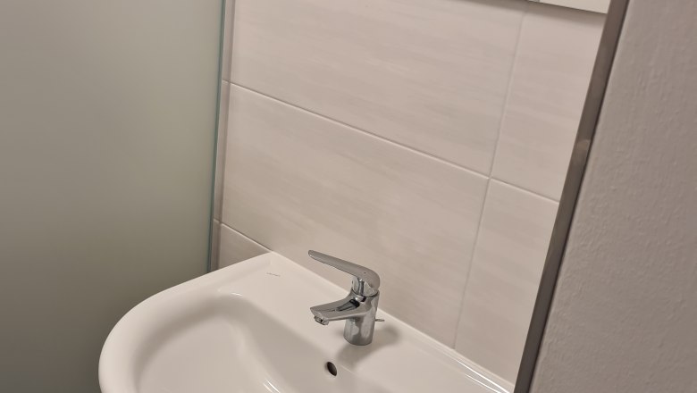 TDR-GasthofKirchenwirth-Badezimmer, © Josef Burger Modernes Badezimmer mit Waschbecken und Spiegel.