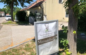 Fam. Rauscher, © Donau Niederösterreich Ein Schild vor einem Gebäude mit der Aufschrift 'Mittagsbuffet' und 'Herzlich Willkommen bei Familie Rauscher'.