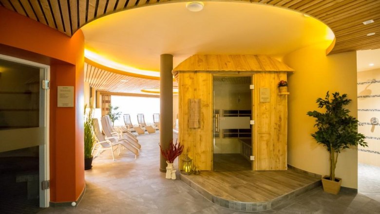 Saunawelt im JUFA Hotel Annaberg***s, © Fred Lindmoser Innenansicht einer Saunalandschaft mit Holzsauna und Liegestühlen.