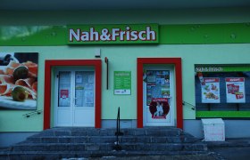 Nah und Frisch, © NÖ-BBG Eingang eines Nah&Frisch-Ladens mit Werbeplakaten und Schaufenster.