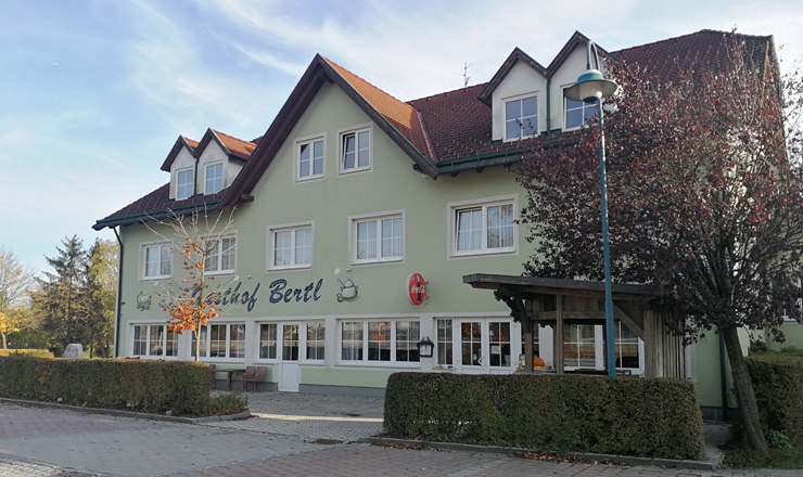 Gasthof Bertl, © Roman Zöchlinger A two-storey building with the inscription 'Gasthof Bertl', surrounded by trees and bushes.