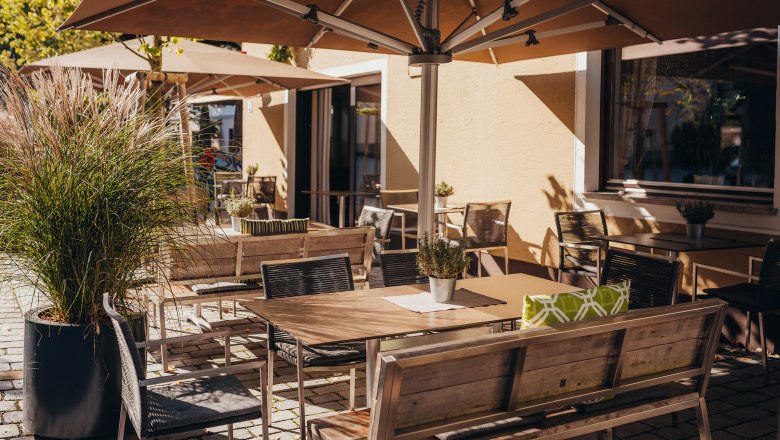 Ein Platz an der Sonne, © Niederösterreich Werbung/Daniela Führer Sonniger Außenbereich eines Cafés mit Tischen, Stühlen und Sonnenschirmen.