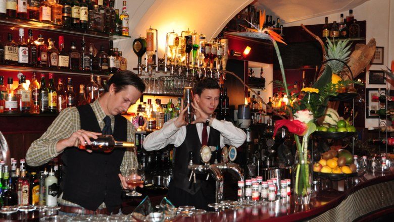 Yesterday, © Yesterday Two bartenders work in a stylish bar with lots of bottles in the background.