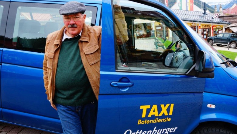 Taxi Orttenburger, © Ernst Miglbauer Ein Mann steht neben einem blauen Taxi mit der Aufschrift 'Taxi Botendienste Orttenburger'.
