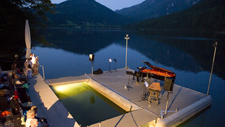 Lunz am See lake stage, © Andreas Elgert Lunz am See lake stage at dusk with piano and spectators.