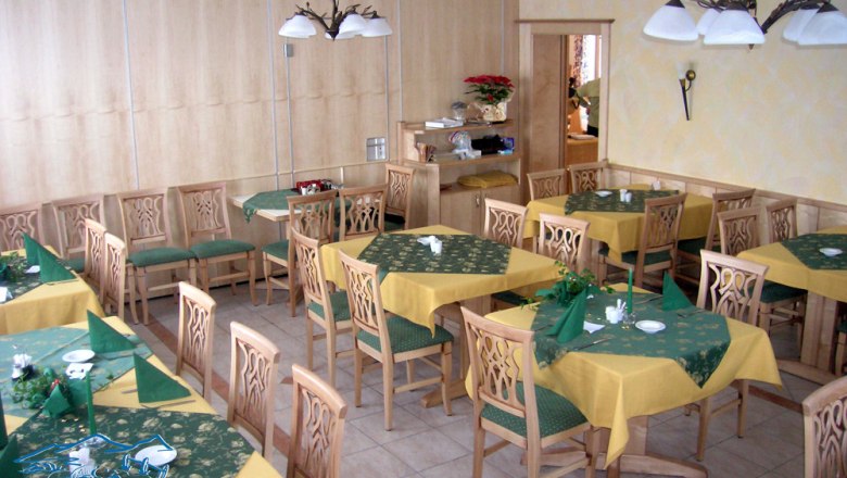 Florian's Teichstüberl - Restaurant, © Teichstüberl Interior view of a restaurant with wooden furniture and yellow-green tablecloths.