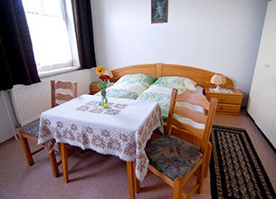 Zimmer, © Martin Herget Gemütliches Zimmer mit Doppelbett, Tisch, zwei Stühlen und Blumen.