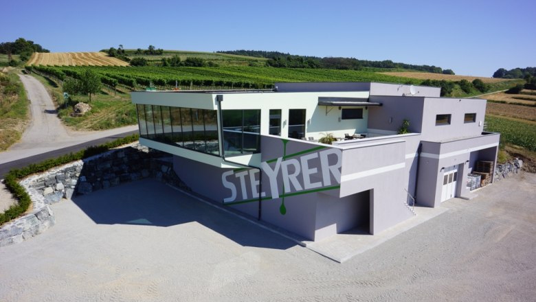 Steyrer Winery, © Weingut Steyrer Modern Steyrer winery with glass façade and surrounding vineyards.