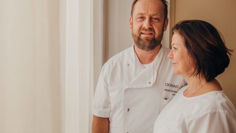 Host and head chef Ernst Gruber, hostess Karin Rosenberger, © Niederösterreich Werbung/Daniela Führer A man and a woman in white chef's jackets stand next to each other in front of a window.