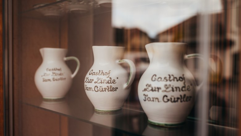 Special: The Mönchskeller, © Niederösterreich Werbung/Daniela Führer Three jugs with the inscription "Gasthof Zur Linde Fam. Gürtler" in a display case.