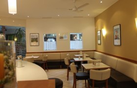 Bäckerei-Konditorei Fürst, © Stadtgemeinde Scheibbs Innenansicht eines Cafés mit Tischen, Stühlen und Wanddekorationen.