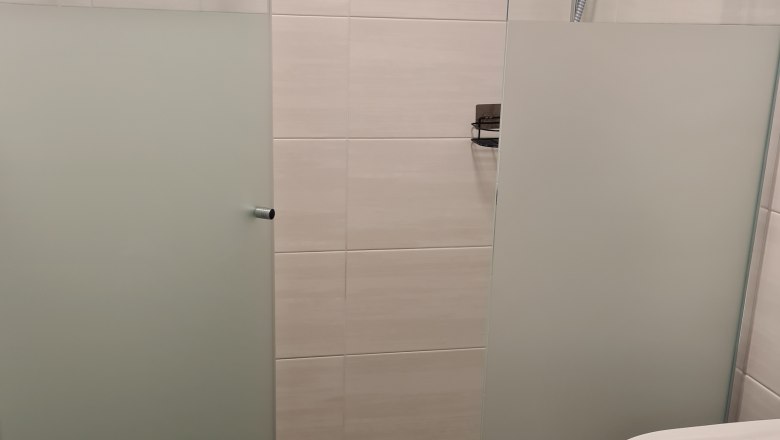 TDR-GasthofKirchenwirth-Dusche, © Josef Burger Moderne Dusche mit Glaswänden und Duschkopf in einem Badezimmer.