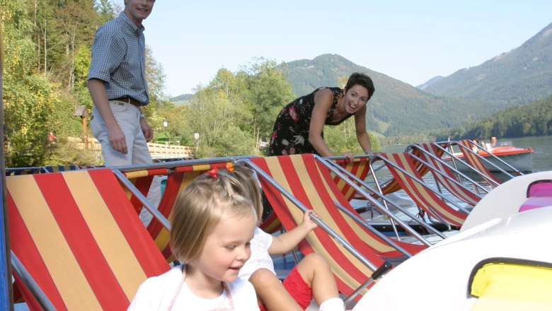 Children on the pedal boat, © weinfranz.at Family with children on pedal boats on a lake with mountains in the background.