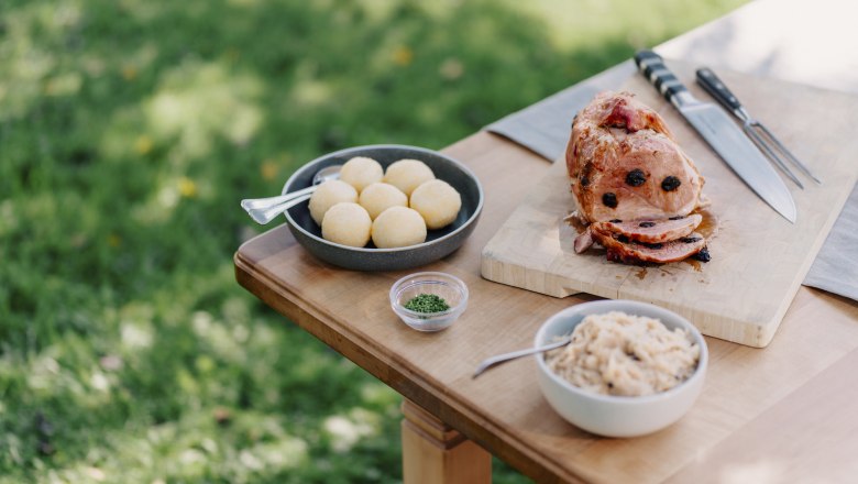 Cider roast larded with prunes, © Niederösterreich Werbung/Julius Hirtzberger Mostbratl with dried plums served on an outdoor table.