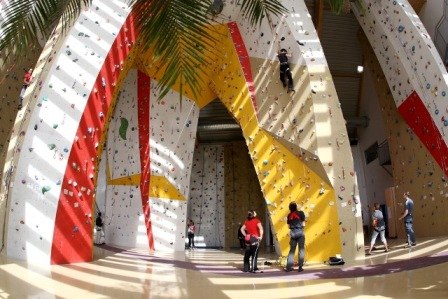 Climbing hall Weinburg, © Gemeinde Weinburg Interior view of a climbing hall with colorful climbing walls and several people climbing.