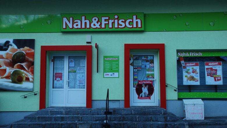 Nah und Frisch, © NÖ-BBG Eingang eines Nah&Frisch-Ladens mit Werbeplakaten und Schaufenster.