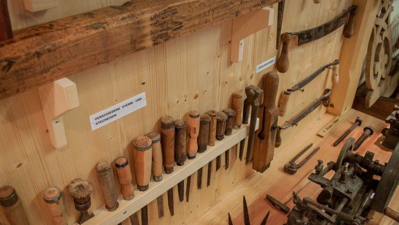 Various chisels and pry bars, © Rene Jagersberger A collection of wooden tools, including chisels and chisels, displayed on a wooden wall.